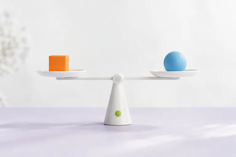 Balance en équilibre entre deux objets colorés, arbitrage entre SEO et annonces de marque